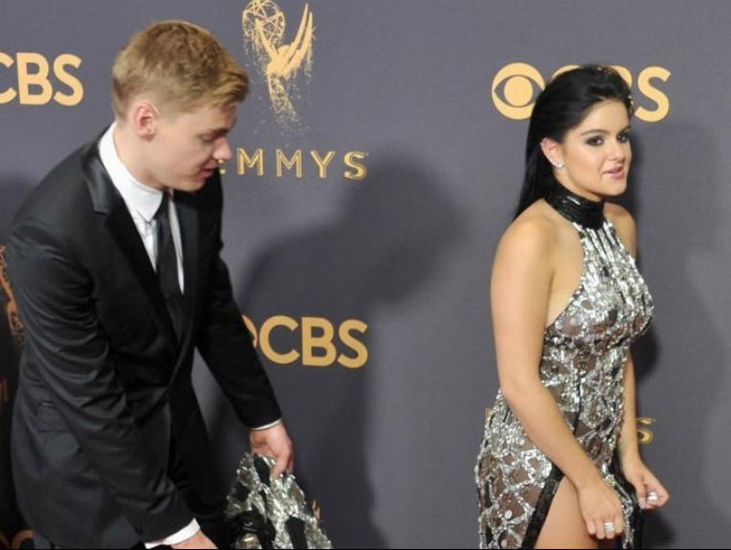 Levi Meaden helps Ariel Winter with the trail of her black and silver glistening gown.