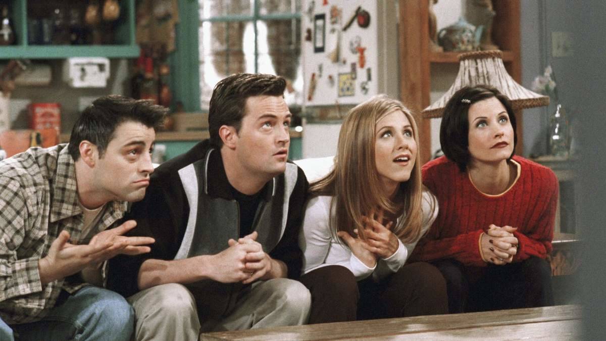 the cast of friends looking up from a couch