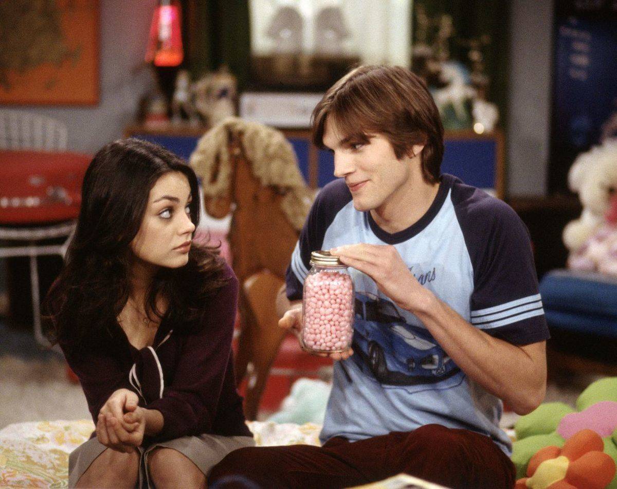 mila kunis and ashton kutcher sitting in a kid's room