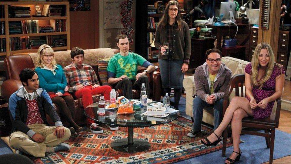 the cast of the big bang theory sitting in a living room