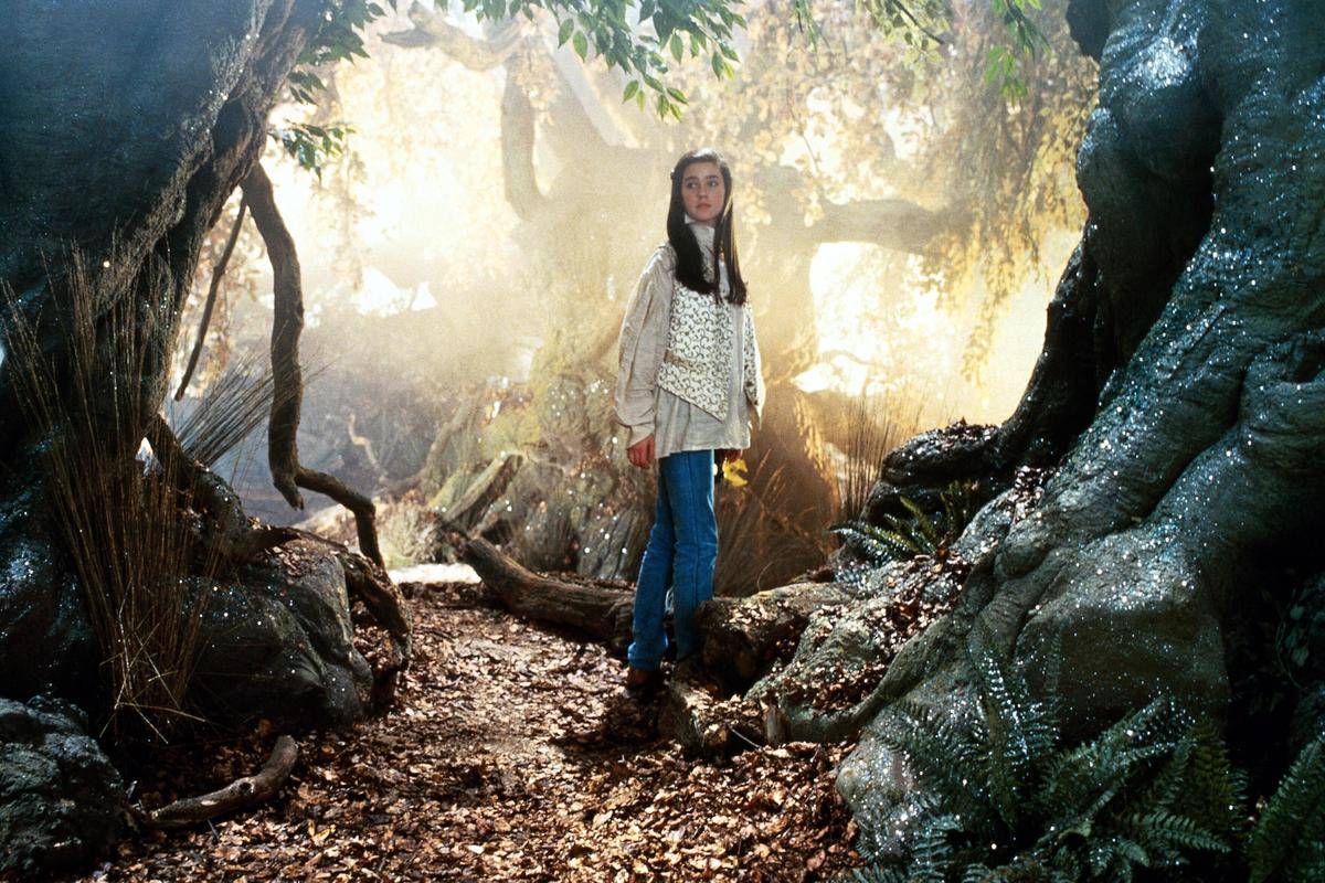 Jennifer Connelly stands in a forest in this Labyrinth publicity still.
