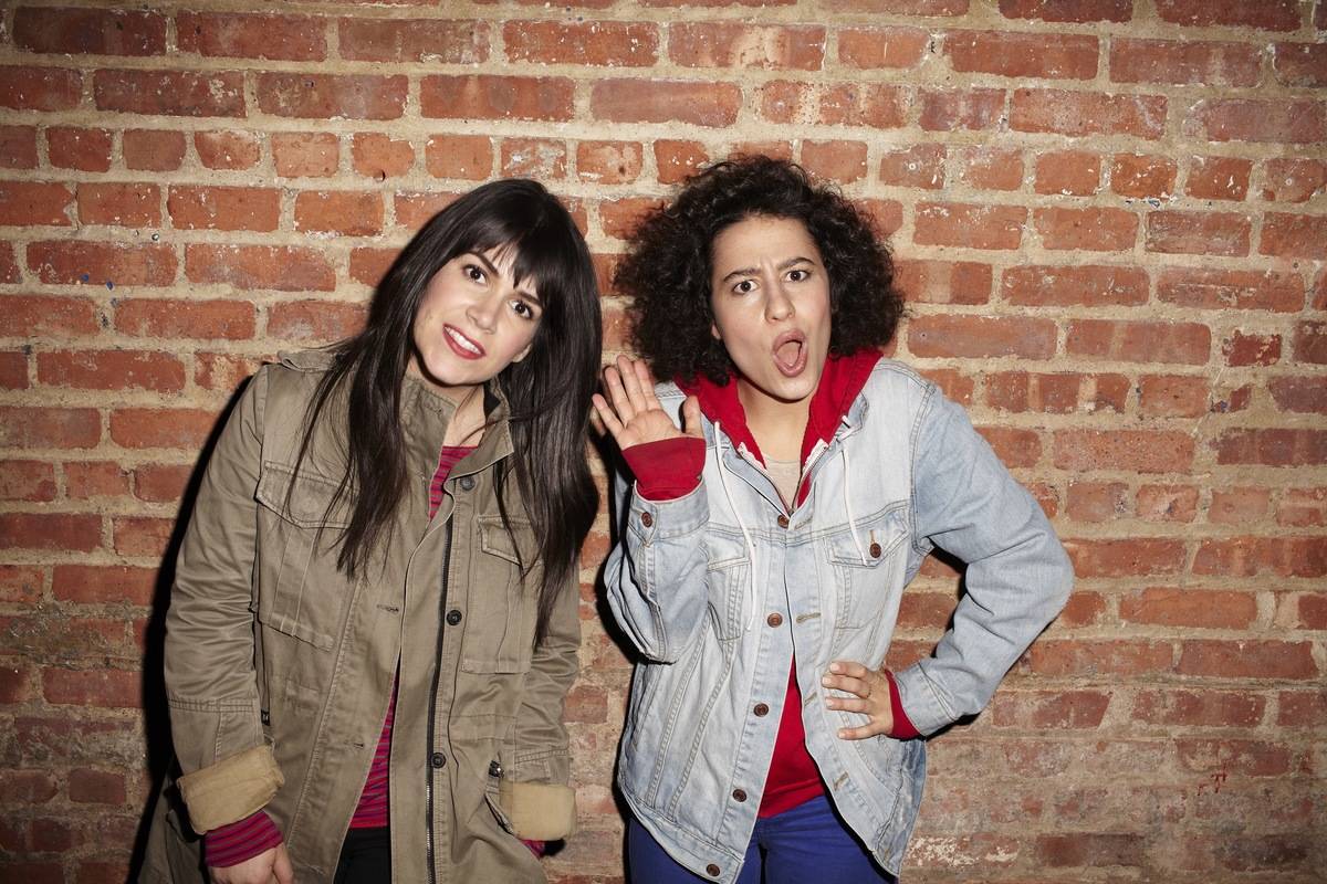Abbi Jacobson and Ilana Glazer standing in front of a brick wall on broad city