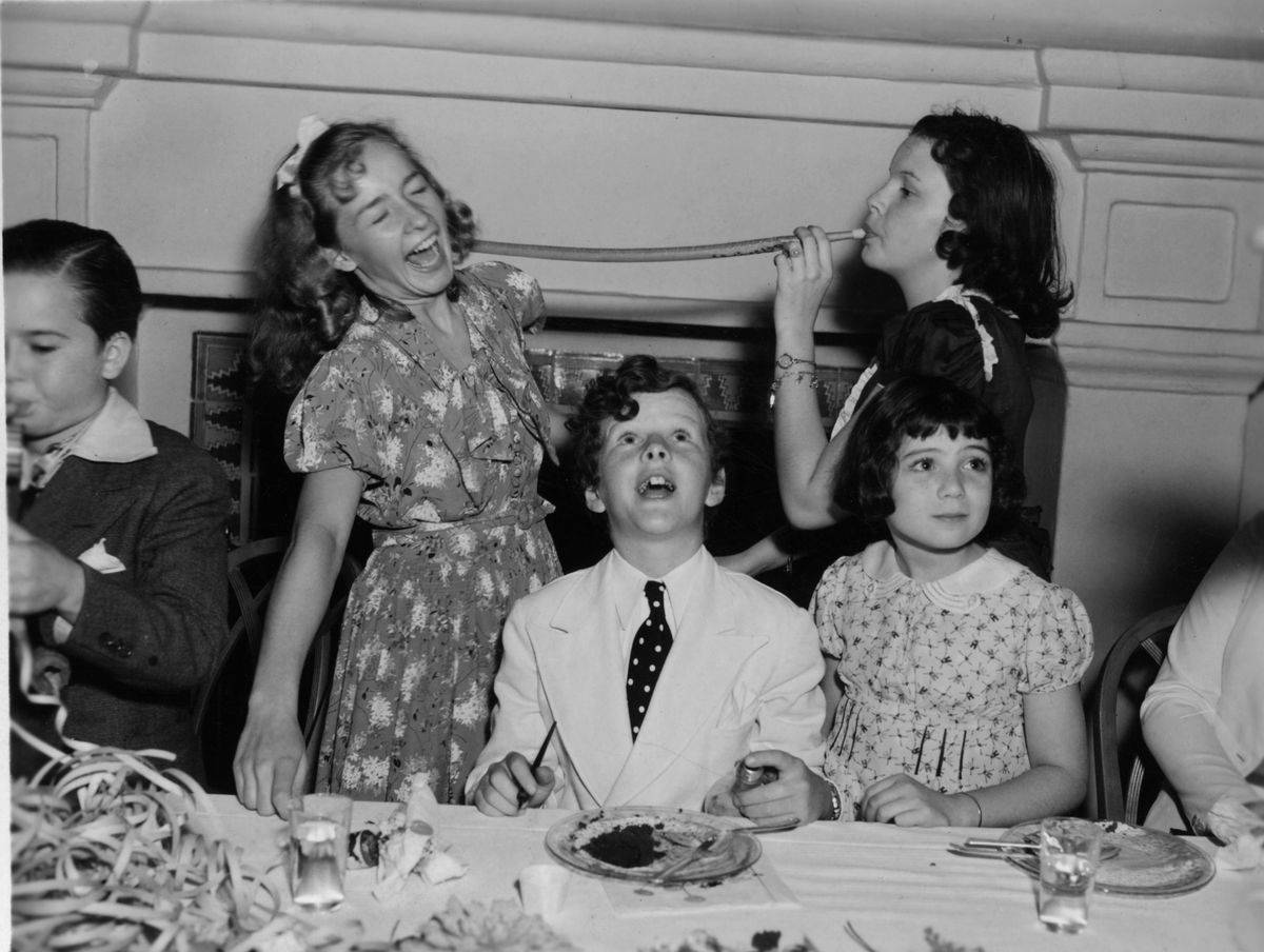 circa 1931: Child actors at a tea party; from left to right, standing, Bonita Granville, Judy Garland, and sitting, Tommy Kelley and Sybil Jason.