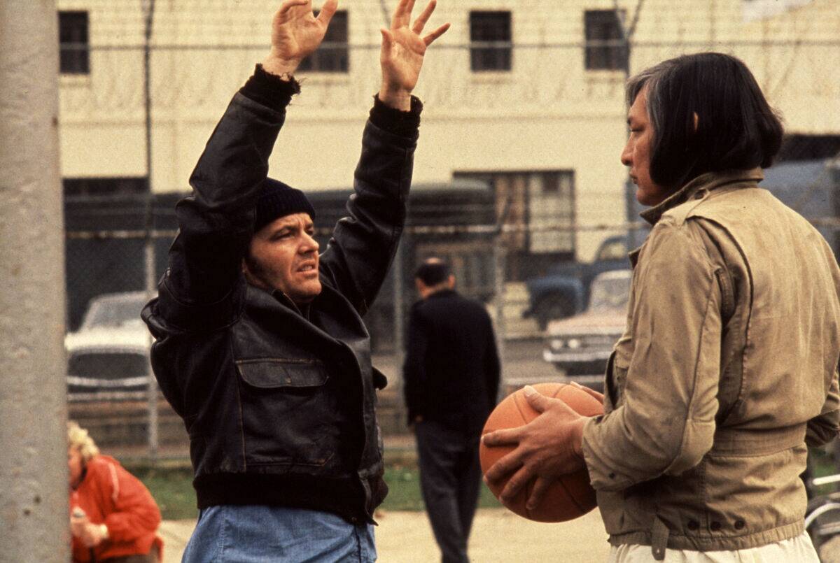Jack Nicholson putting his hands up as Randle McMurphy while Will Sampson holds basketball as Chief Bromden in One Flew Over the Cuckoo's Nest