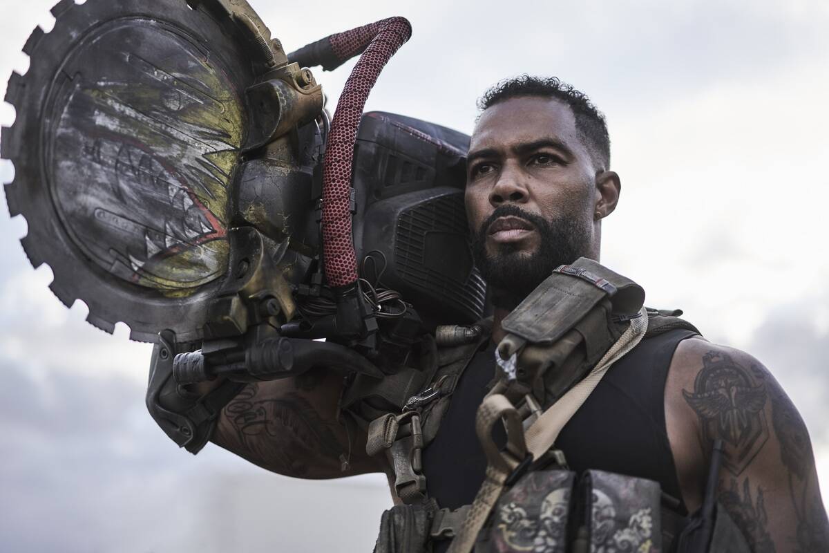 Omari Hardwick holding giant saw on his shoulder in Army of the dead